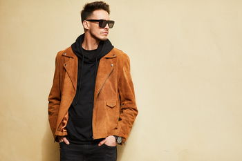 Zu sehen ist ein Mann in Lederjacke mit einer eckigen Sonnenbrille.